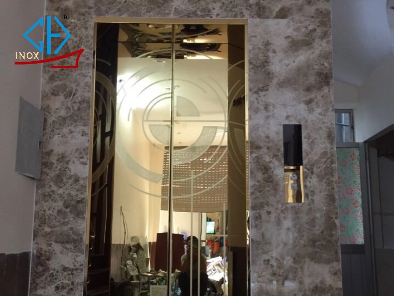 Cabin inox thang máy vàng hoa văn bán nguyệt